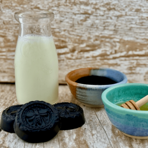 goat milk facial bar with activated charcoal and honey shown with ingredients