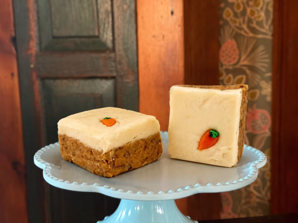 two pieces of Carrot Cake Goat Milk Fudge on a cake stand