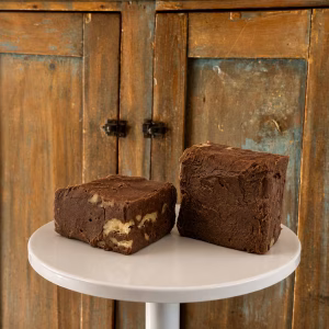 two pieces of Chocolate Walnut Goat Milk Fudge on a cake stand