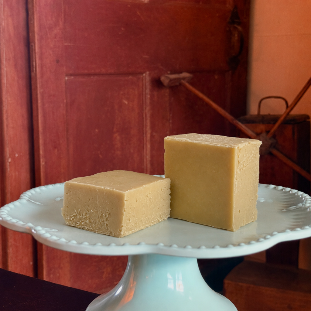 two pieces of Classic Maple Goat Milk Fudge on a cake stand