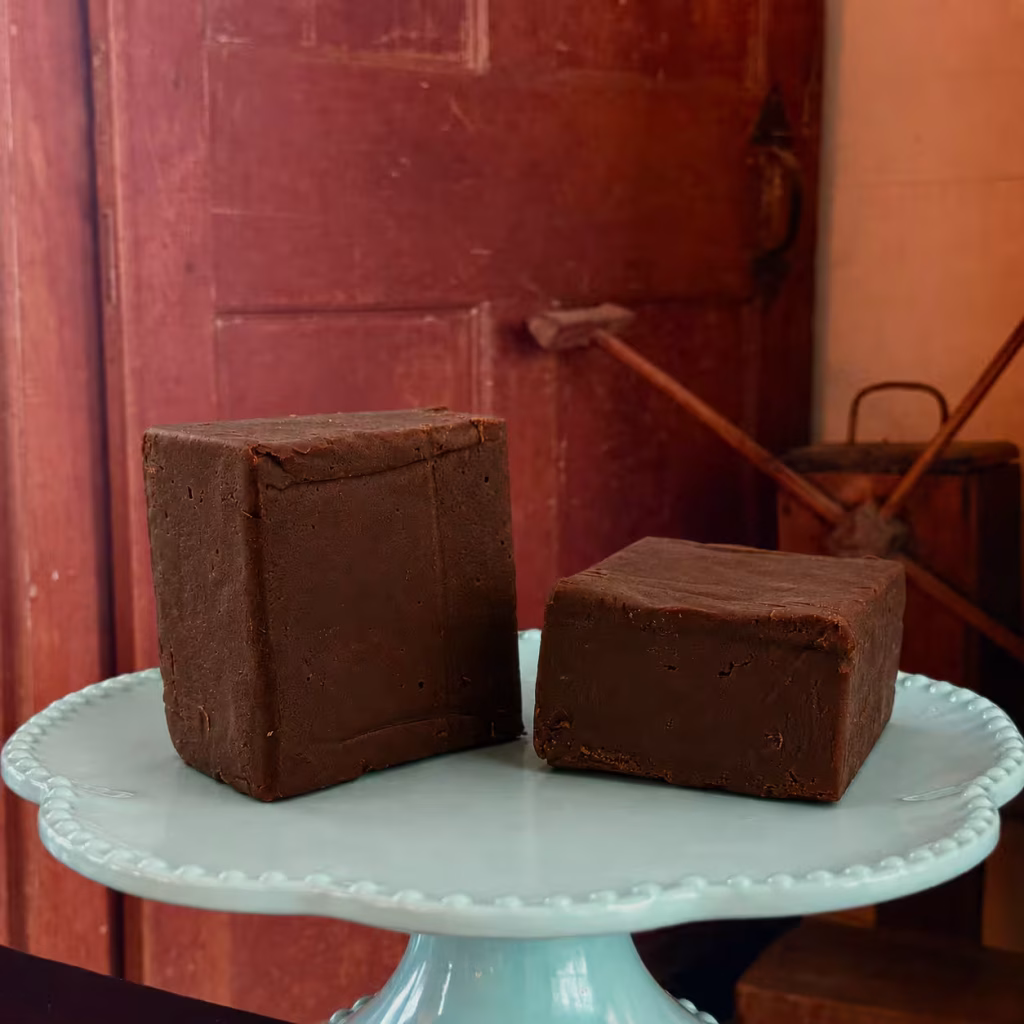 two pieces of Goat Milk Dark Chocolate Marquette Fudge on a pedestal